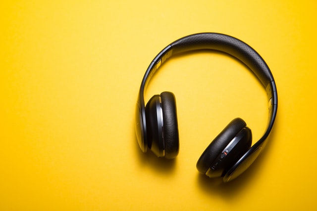 Black noise cancelling headphones on a bright yellow background