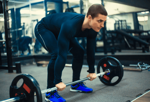 Man gripping barbell, preparing to deadlift