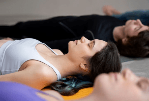 People lying on yoga mats in savasana pose