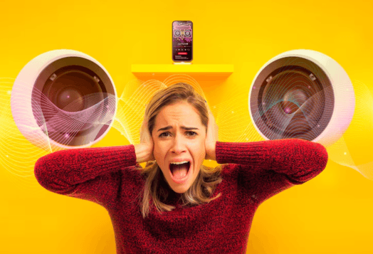 Woman covering ears from loud music from speakers